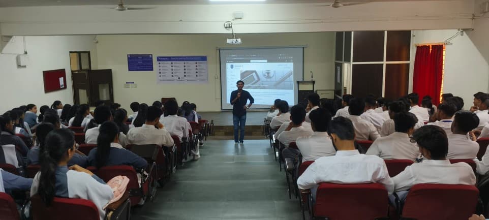 Sayan Karmakar speaking into a microphone in the CDGI auditorium